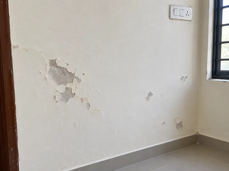 Wall with small peeling patches and minor paint damage